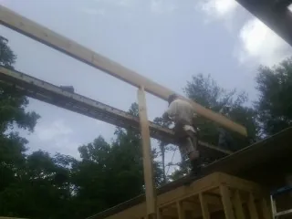 Carpenter setting a ridge beam over a new addition frame — Ice Dam Removal by Roofing Brothers in Mountain Dale