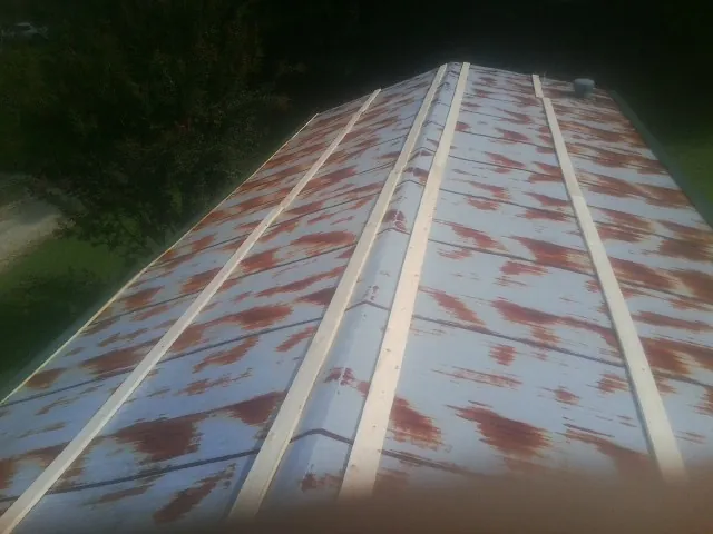 Rusted metal roof panels with new wood purlins before replacement — Storm Damage Roof Repair in Mountain Dale by Roofing Brothers